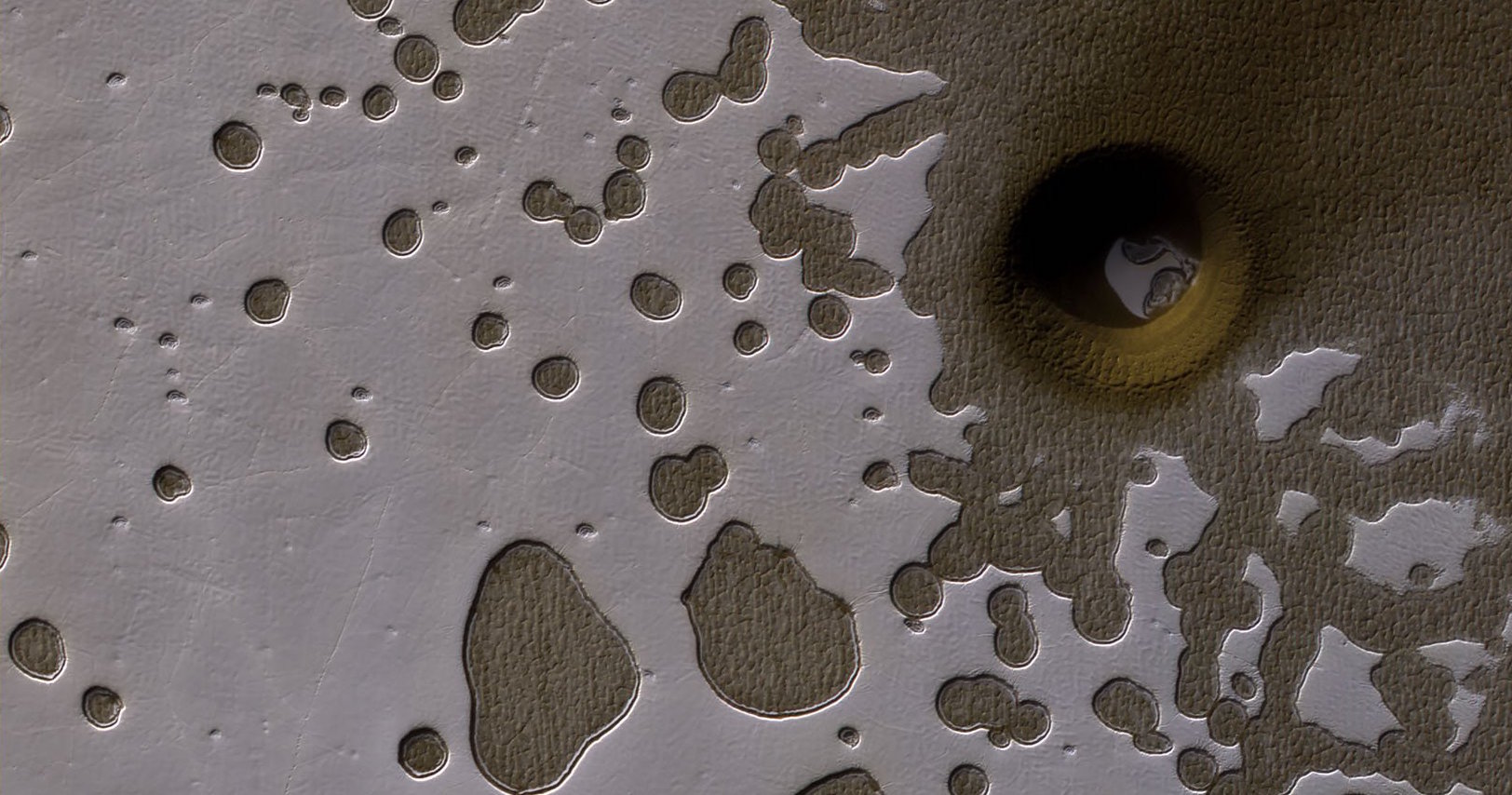 La sonda Mars Reconnaissance Orbiter encontró un agujero pecluiarmente grande en Marte