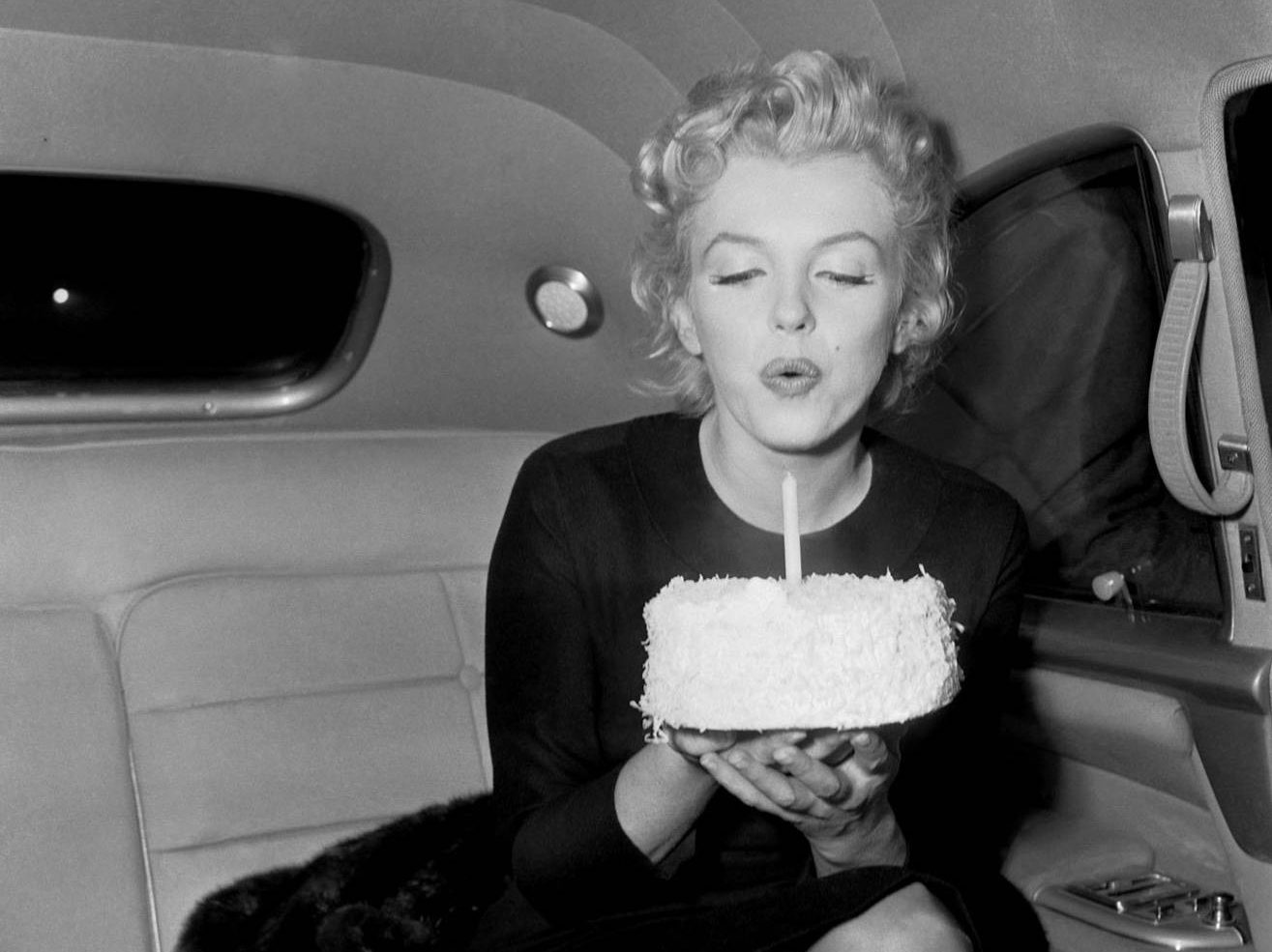 Marilyn Monroe soplando la vela de un pastel de cumpleaÃ±os