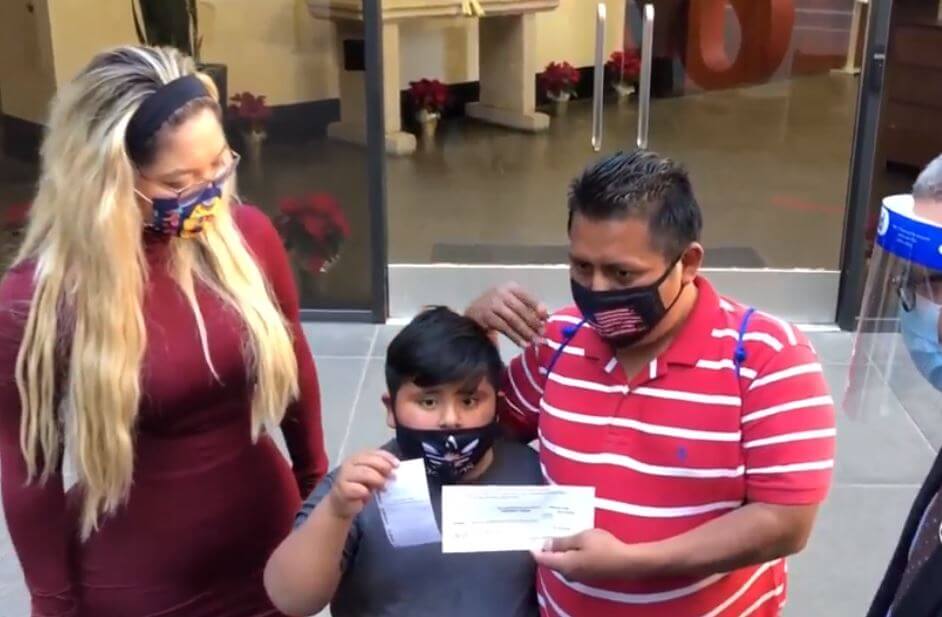 Niño inmigrante recibe cheque por 800 mil pesos