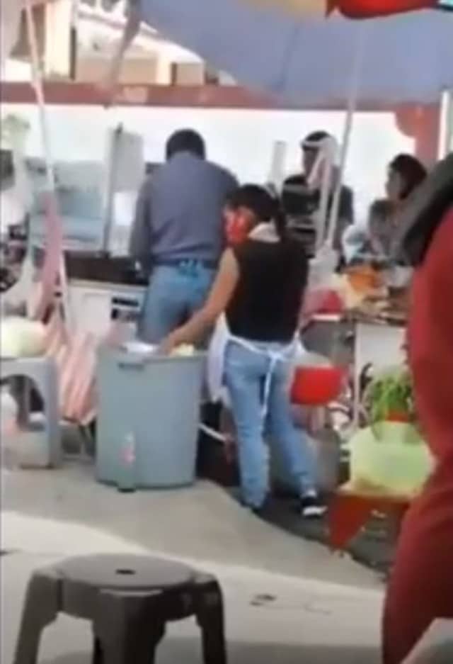 Mujer es grabada sacando platos de la basura para reusarlos en puesto de comida