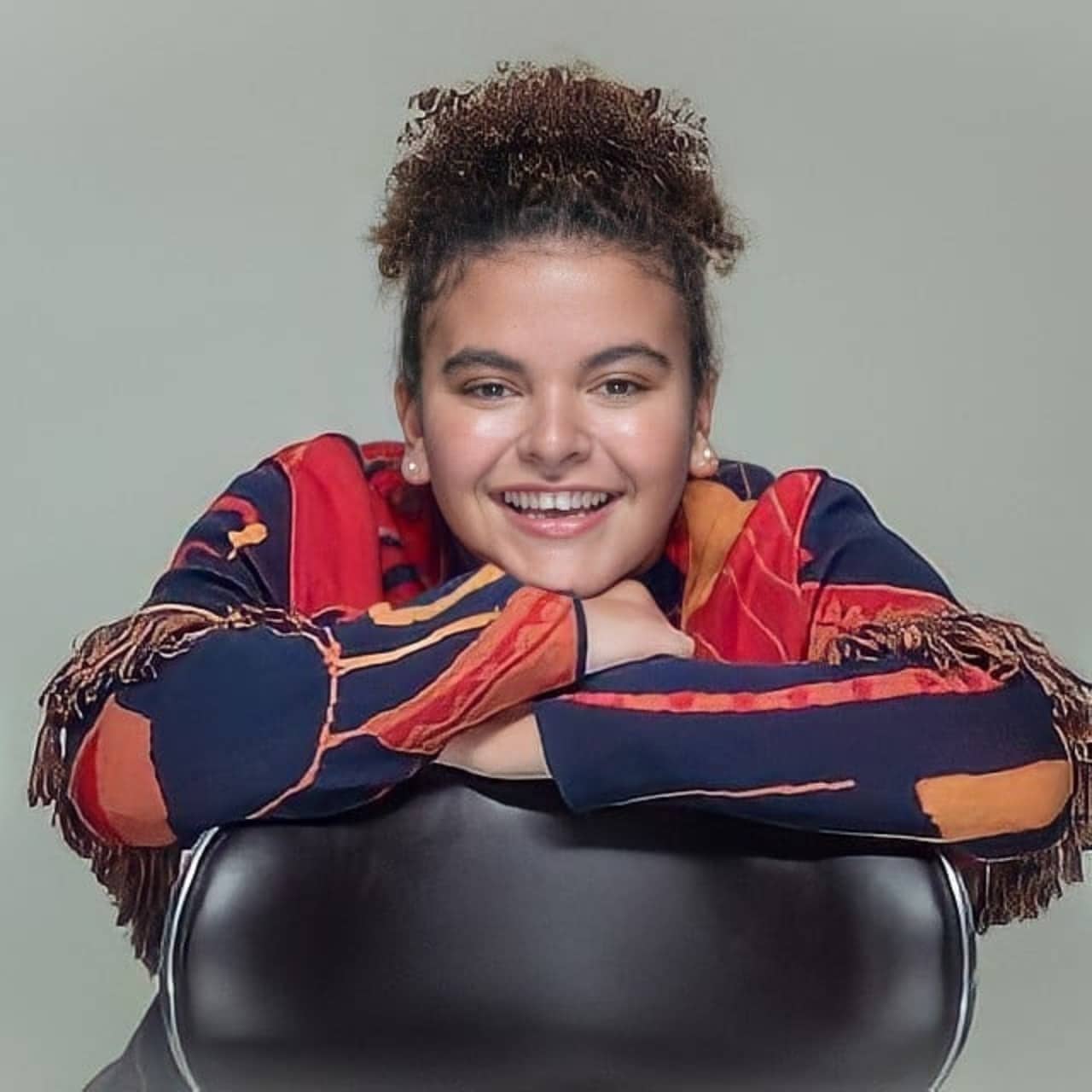 Lucero Mijares sonriendo sentada en silla