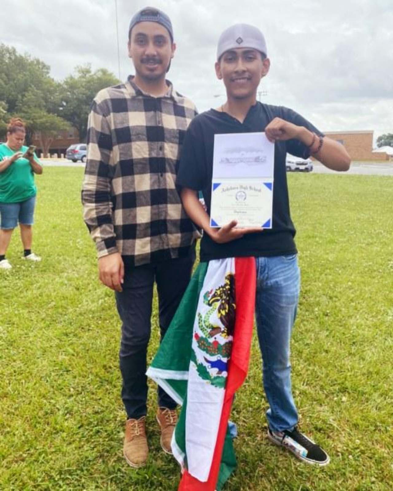 Entregan diploma chico bandera graduacion
